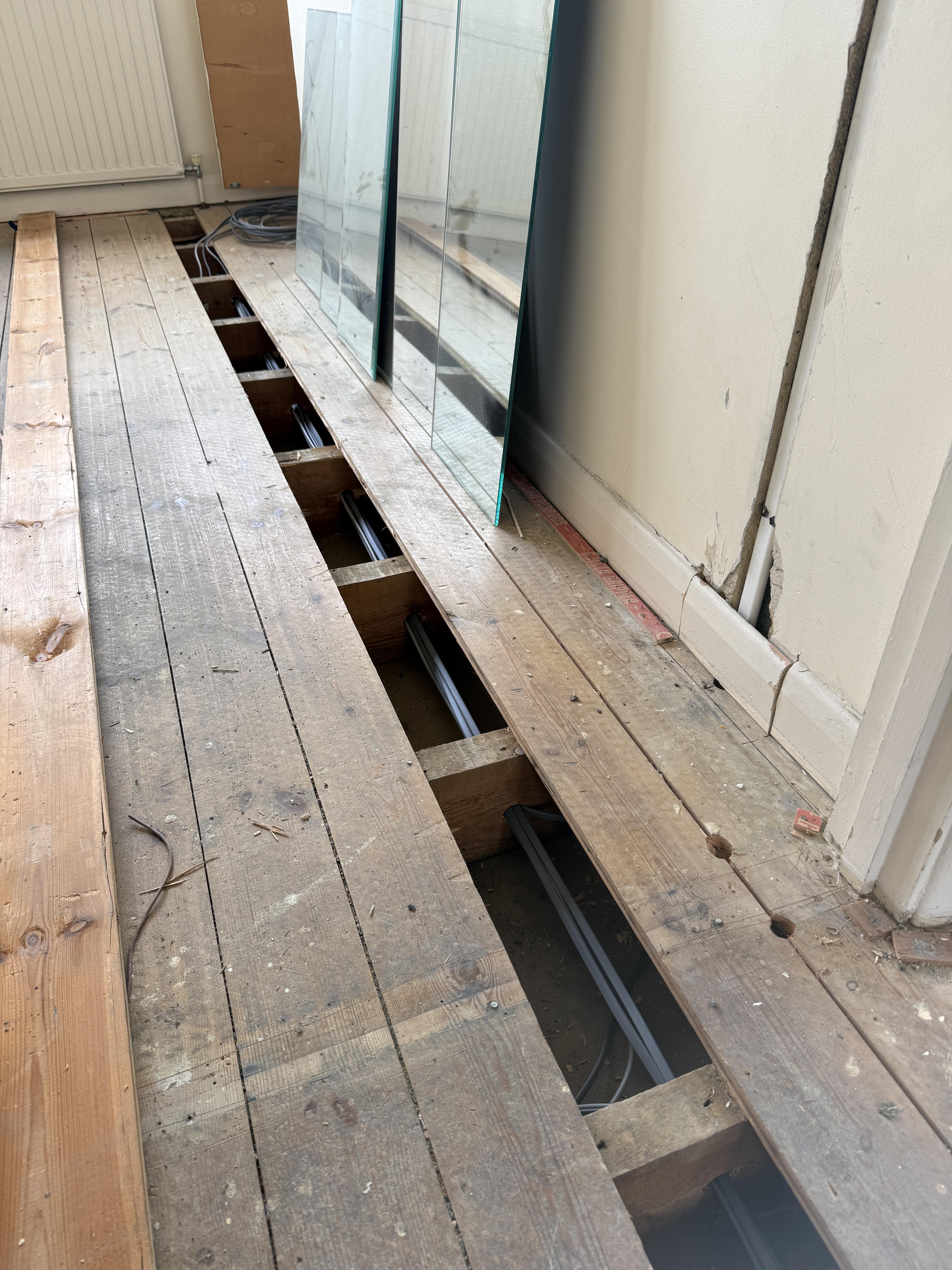 Floorboards lifted and new cable run during a house rewire in Walton-on-Thames